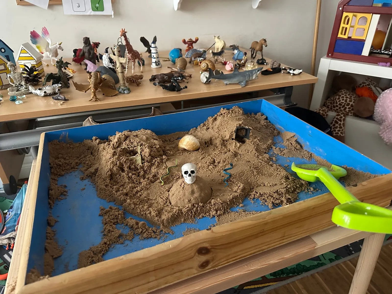 A sandtray with surrounding figures